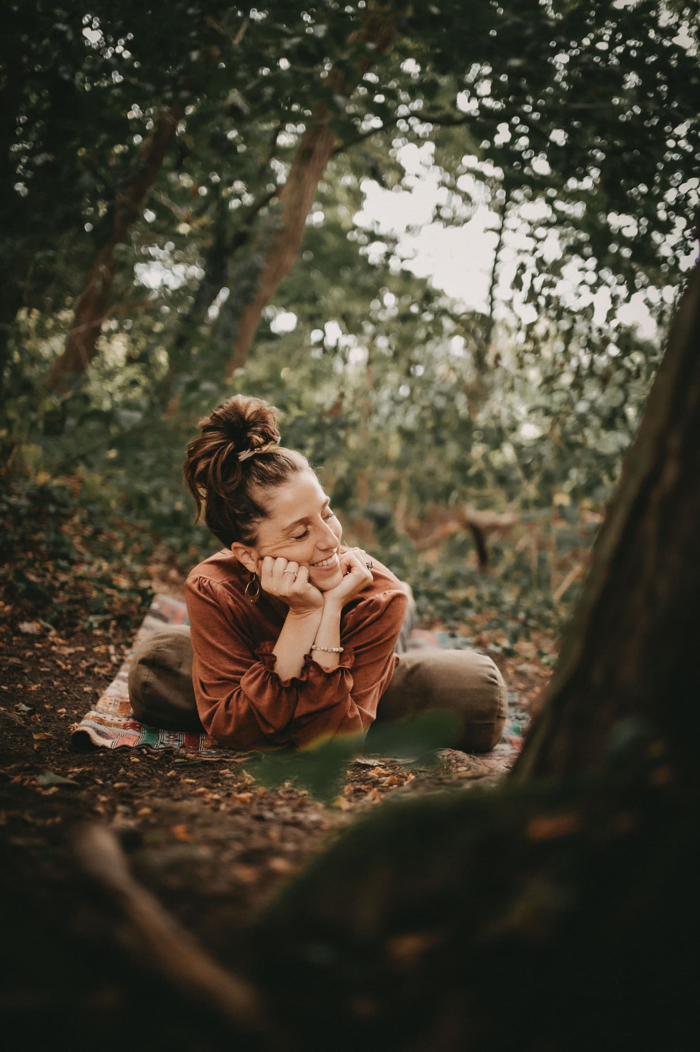 lächelnde frau liegt auf yogamatte im wald