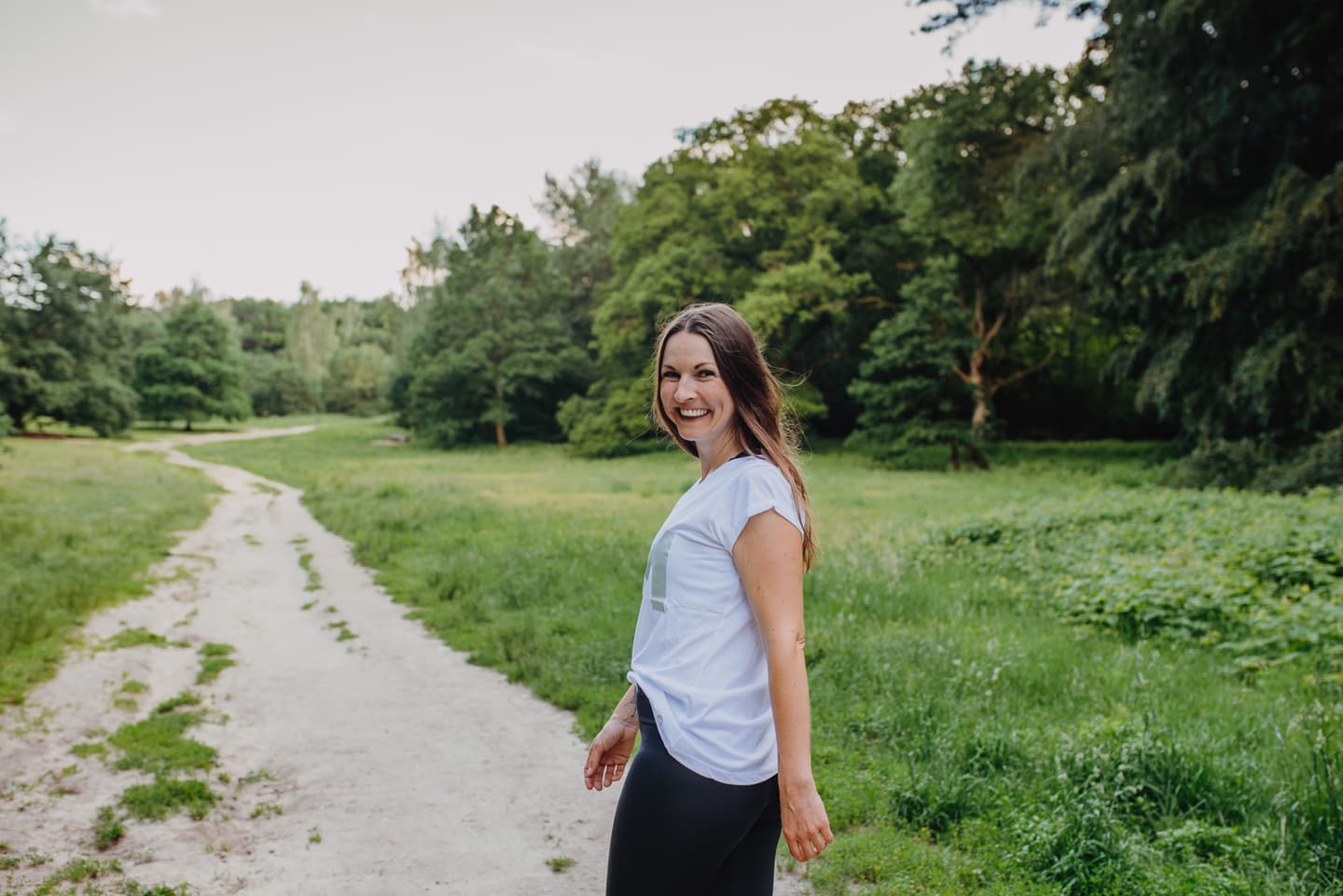 lachende frau auf waldweg